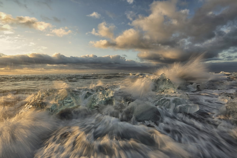 Waves from the atlantic ocean crashes over icebergs along the coast at sunrise iceland Canvas Art - Robert Postma Design Pics (38 x 24)