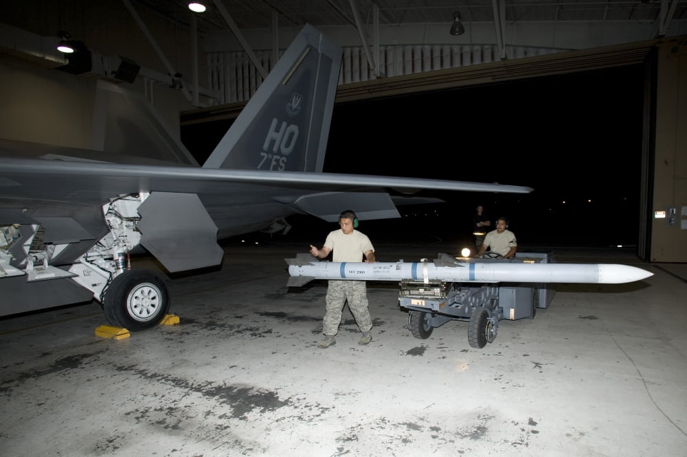 Weapons loaders load and AIM-120 missile on an F-22 Raptor Canvas Art - HIGH-G ProductionsStocktrek Images (18 x 12)