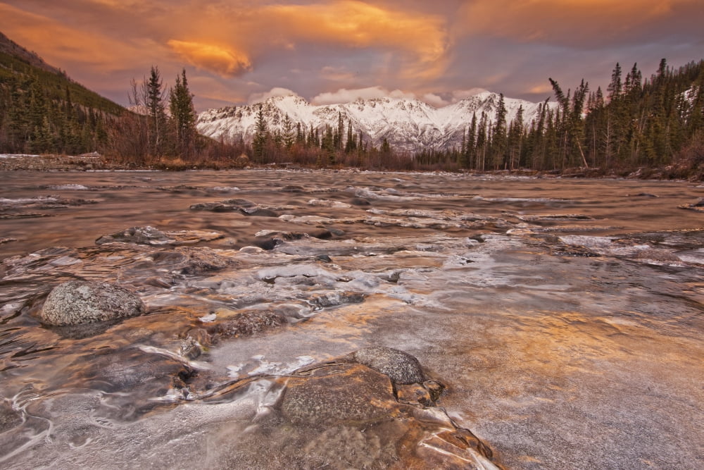 The Wheaton River In Early Winter With The Clouds Lit By Sunset Light Snow Covered Mountains Seen In The Distance Located Outside Of Whitehorse Yukon Canvas Art - Robert Postma Design Pics (17 x 11)