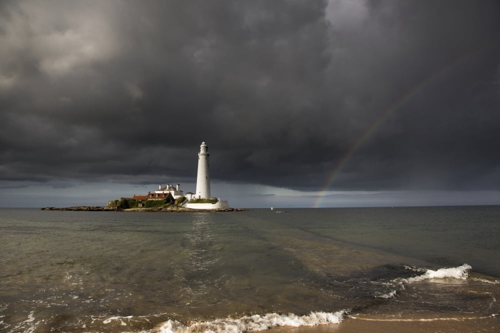 White Lighthouse Illuminated By Sunlight Under A Dark Stormy Sky With A Rainbow St Marys Island Northumberland England Canvas Art - John Short Design Pics (19 x 12)