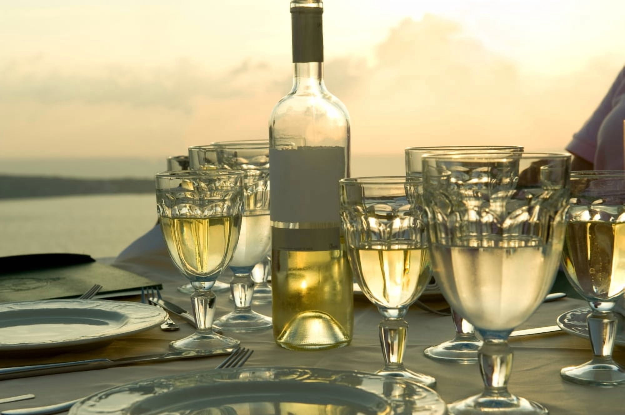 Wine glasses with a wine bottle on a table Ammoudia Santorini Cyclades Islands Greece Canvas Art - Panoramic Images (27 x 9)