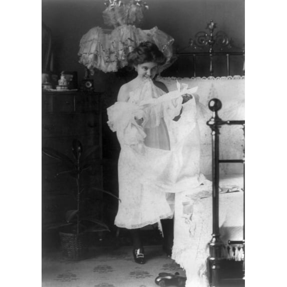 Woman Nightgown C1900. Na Woman Putting On A Nightgown Before Going To Bed. Photograph C1900. Print by