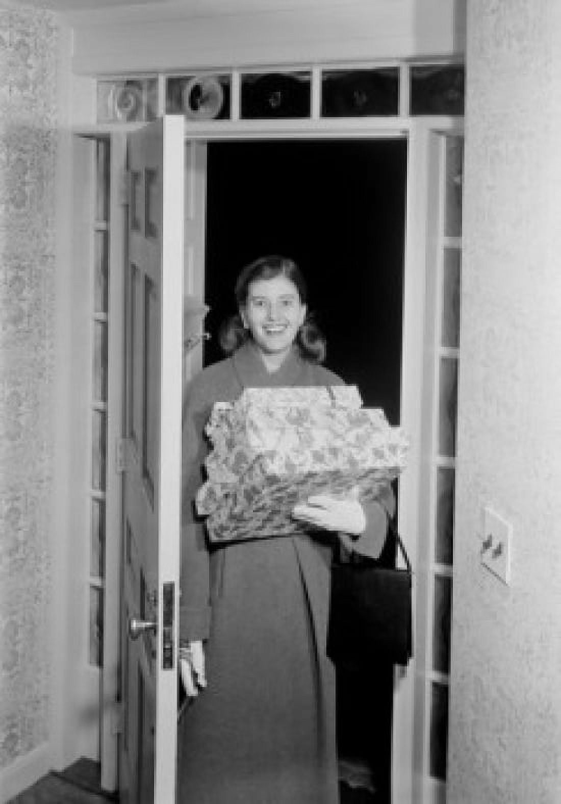 Woman carrying Christmas presents in doorway Canvas Art - (18 x 24)