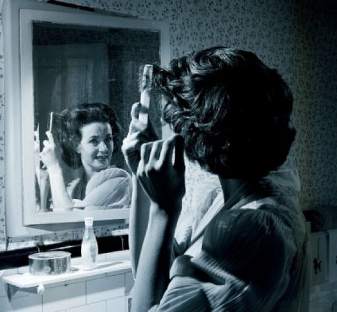 Woman combing hair in front of mirror Canvas Art - (18 x 24)