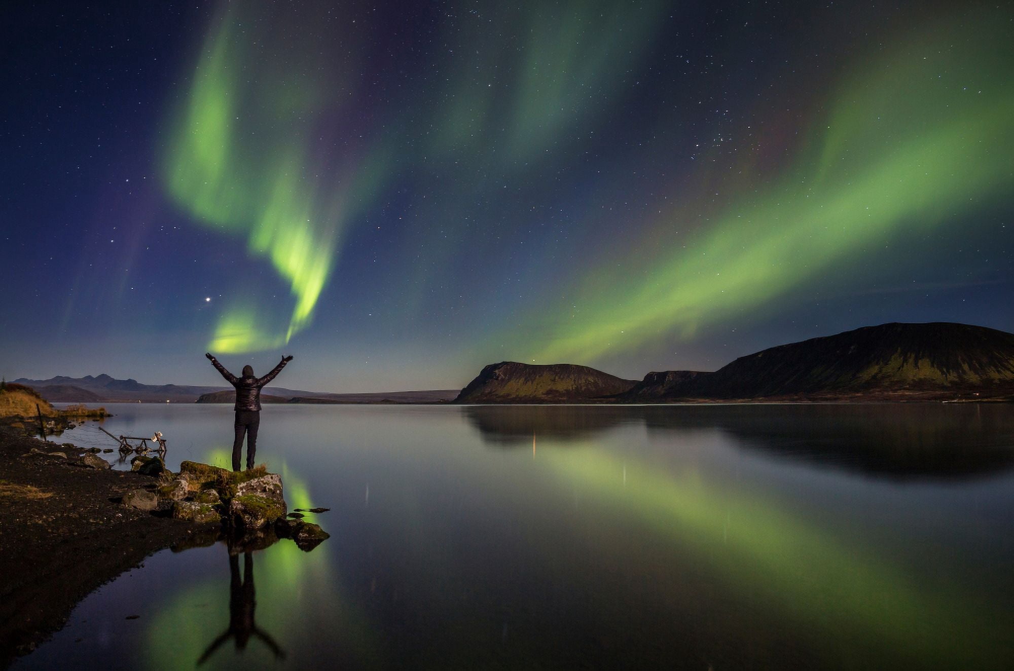 Woman enjoying the view of the Northern Lights at Lake Thingvellir Iceland Thingvellir National Park is a UNESCO World Heritage Site Canvas Art - Panoramic Images (9 x 27)