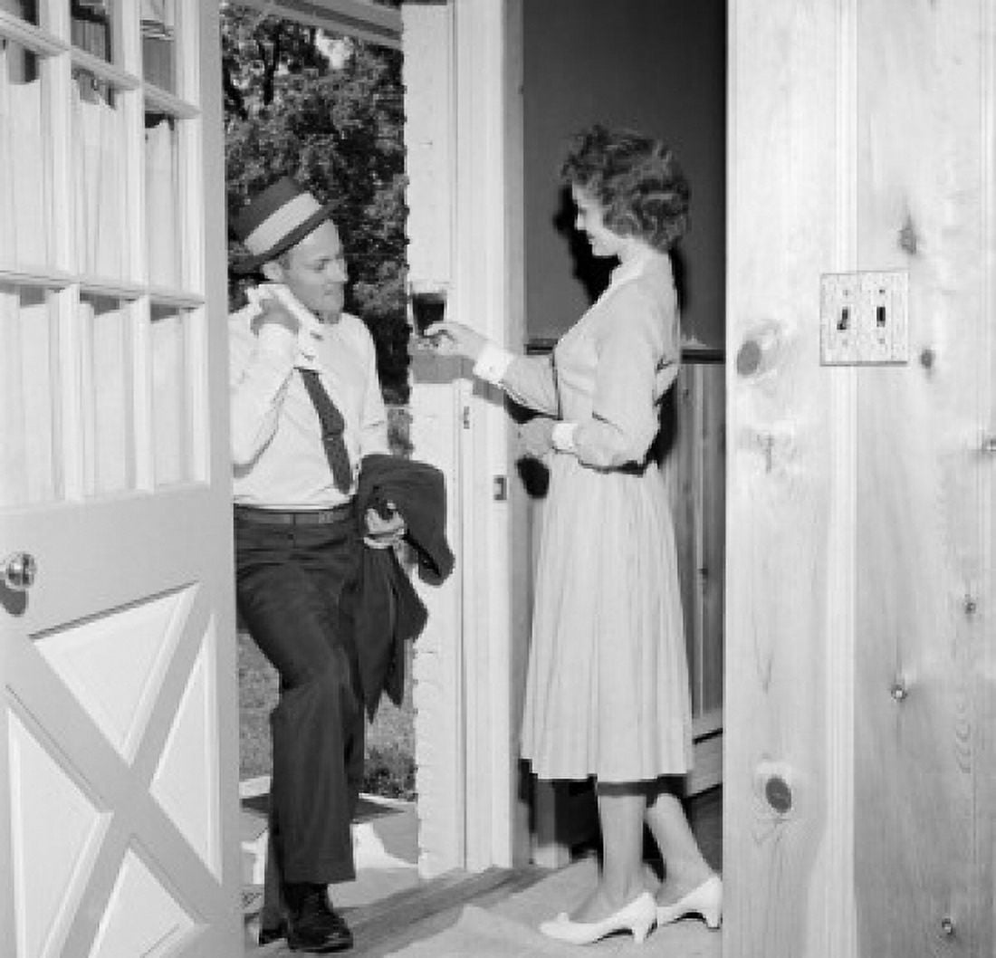 Woman giving husband drink at front door Canvas Art - (18 x 24)