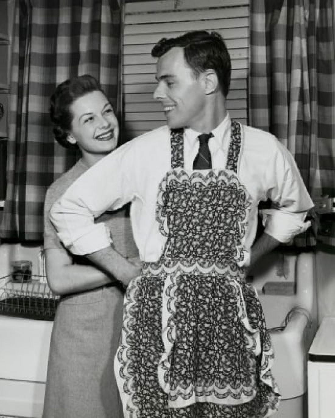 Woman helping man to put on apron Canvas Art - (18 x 24)