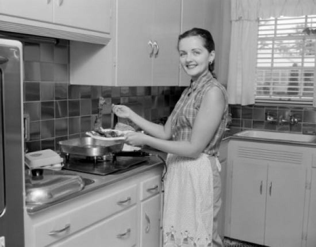 Woman holding plate with food in the kitchen and looking at camera Canvas Art - (24 x 36)
