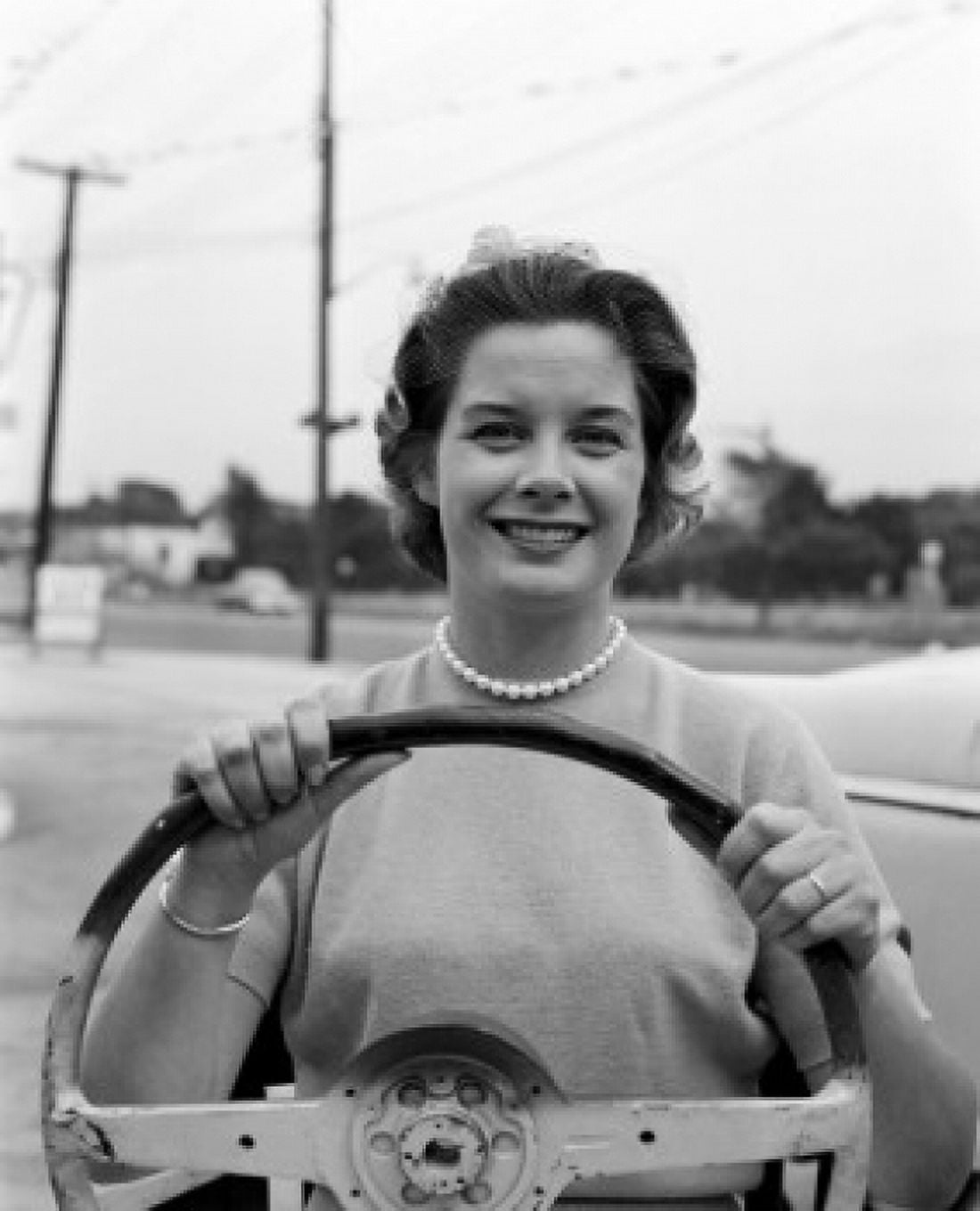 Woman holding steering will and smiling Canvas Art - (24 x 36)