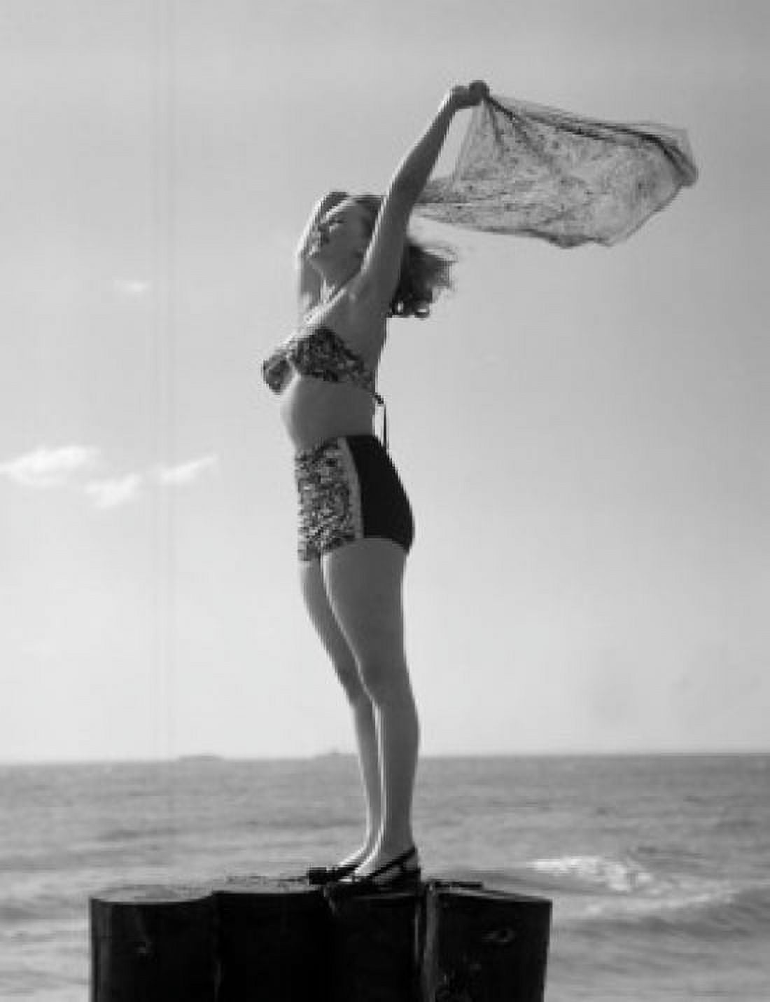 Woman in bikini standing by sea with arms raised and holding scarf Canvas Art - (18 x 24)