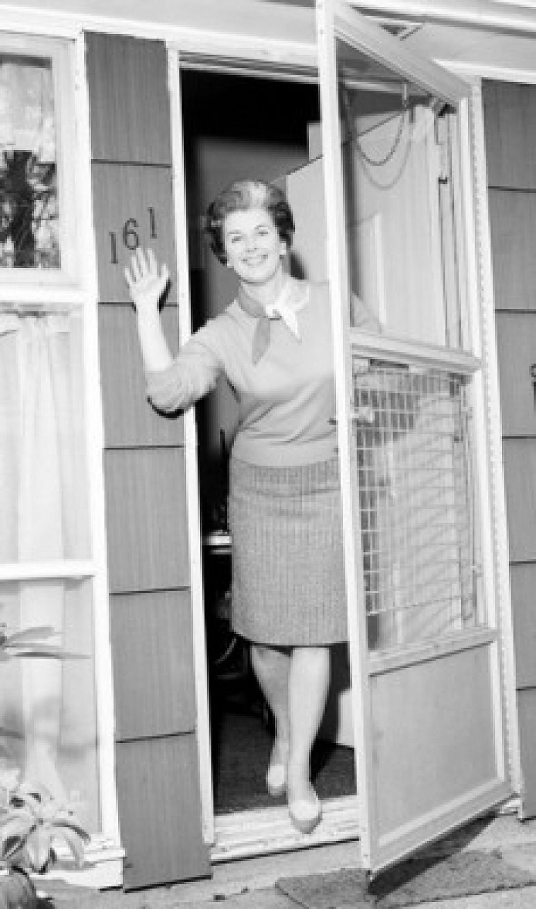 Woman in doorway waving to camera Canvas Art - (18 x 24)
