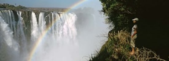 Woman looking at a rainbow over the Victoria Falls Zimbabwe Canvas Art - Panoramic Images (36 x 13)