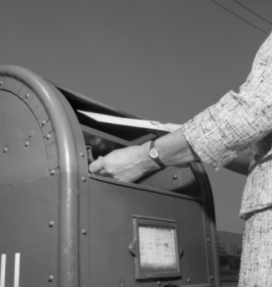 Woman putting mail into mailbox low angle view Canvas Art - (18 x 24)