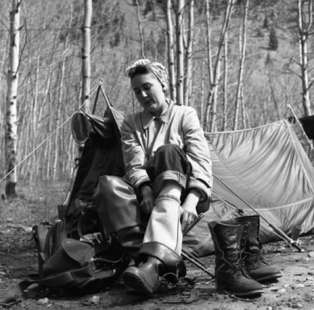 Woman putting on waders in front of tent Canvas Art - (24 x 36)