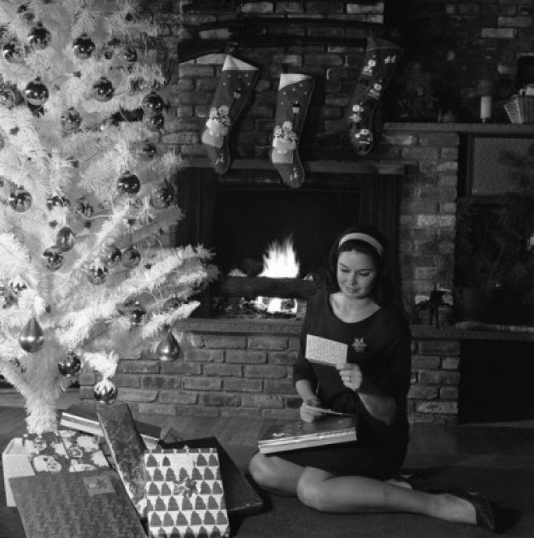 Woman reading card under Christmas tree Canvas Art - (24 x 36)