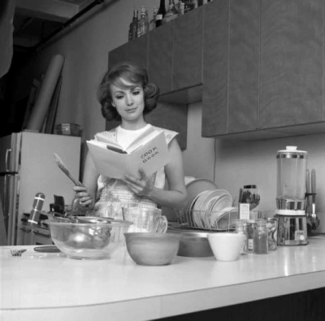 Woman reading cookbook in kitchen Canvas Art - (18 x 24)