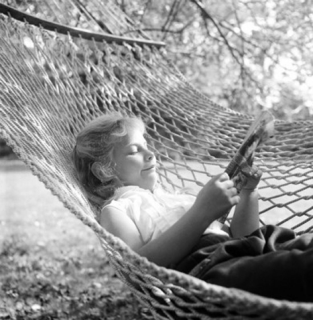 Woman reading newspaper in hammock Canvas Art - (24 x 36)
