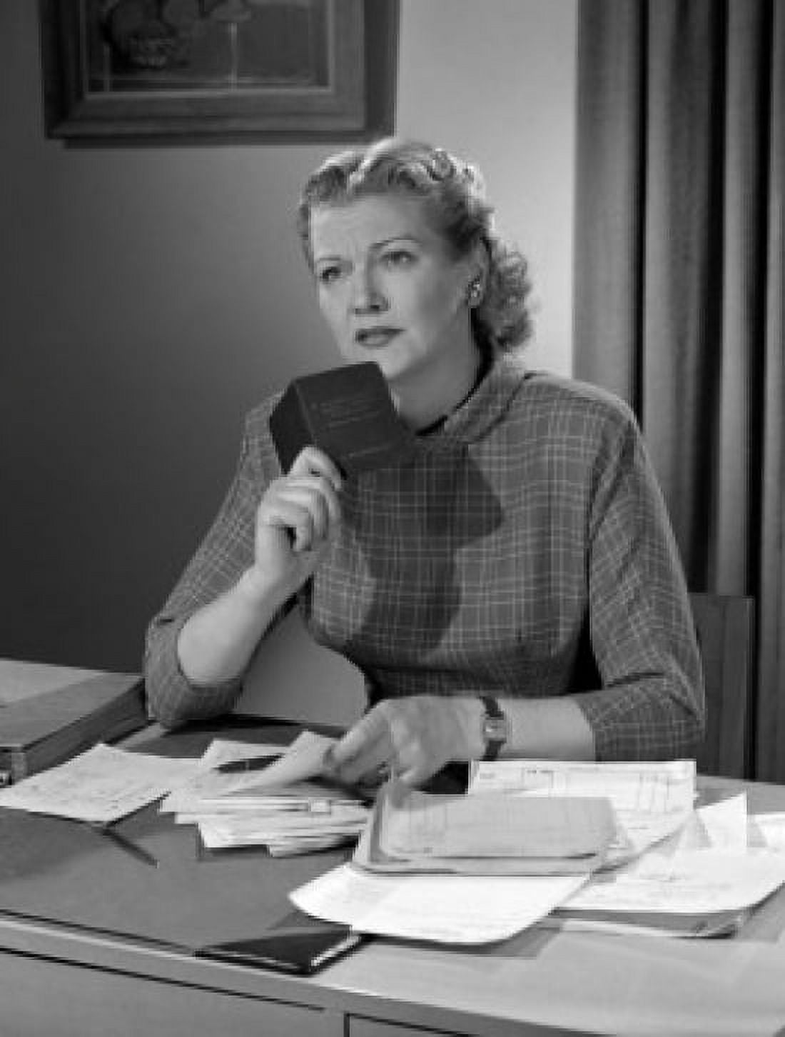 Woman sitting at desk holding booklet Canvas Art - (18 x 24)