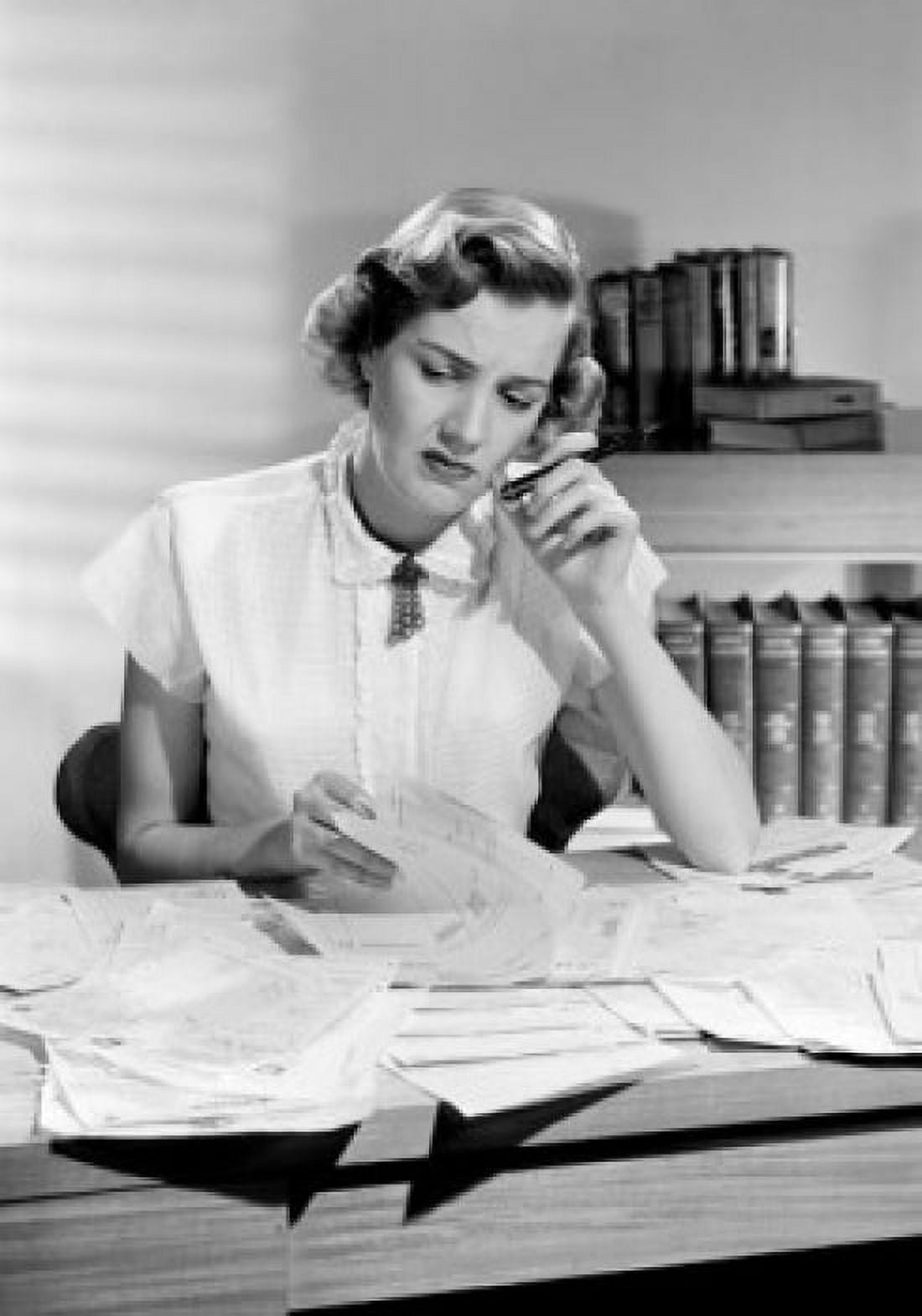 Woman sitting at desk looking at documents Canvas Art - (24 x 36)