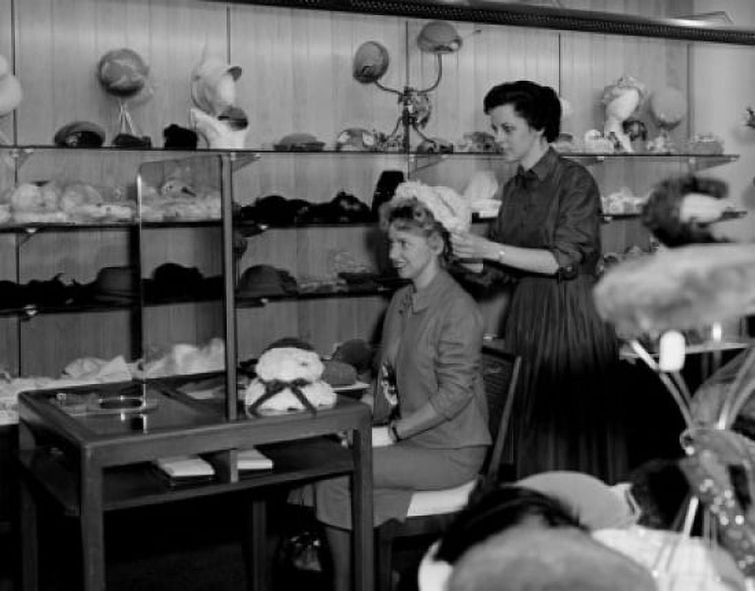 Woman trying on hat in store Canvas Art - (24 x 36)