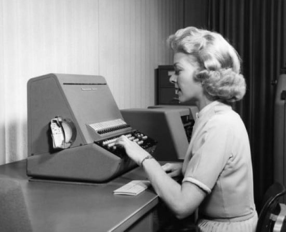 Woman using typewriter in office Canvas Art - (18 x 24)