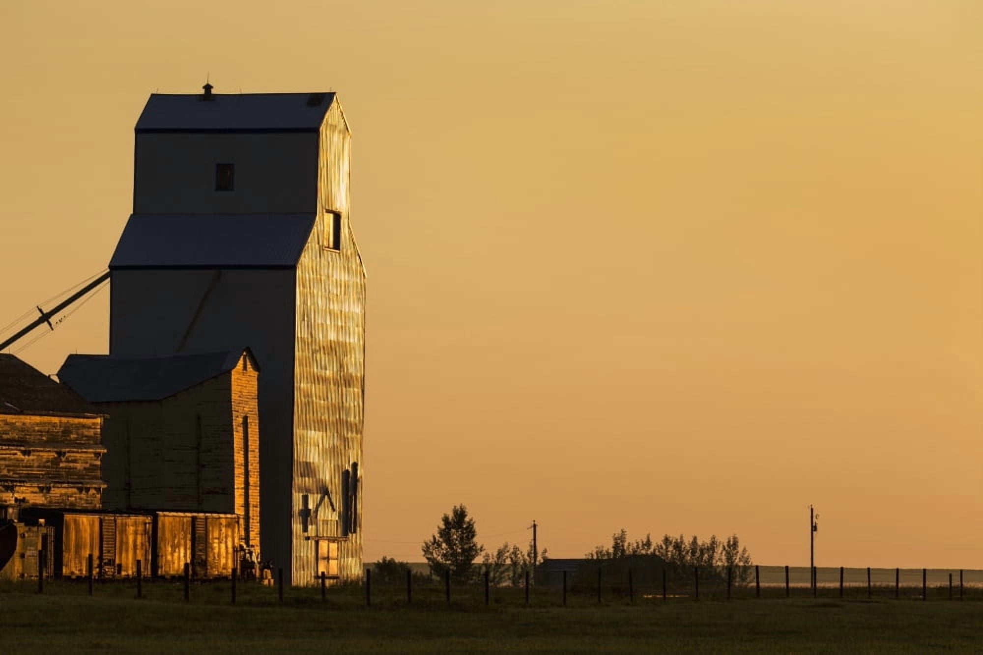 Wooden grain elevator refecting the orange glow of sunrise Mossleigh Alberta Canada Canvas Art - Michael Interisano Design Pics (38 x 24)