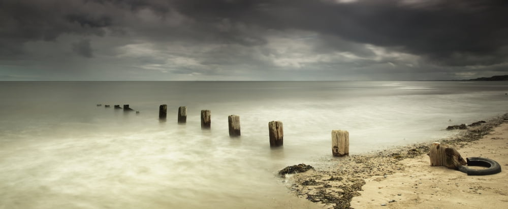 Wooden posts submerged in the water off a beachBerwick northumberland england Canvas Art - John Short Design Pics (33 x 13)