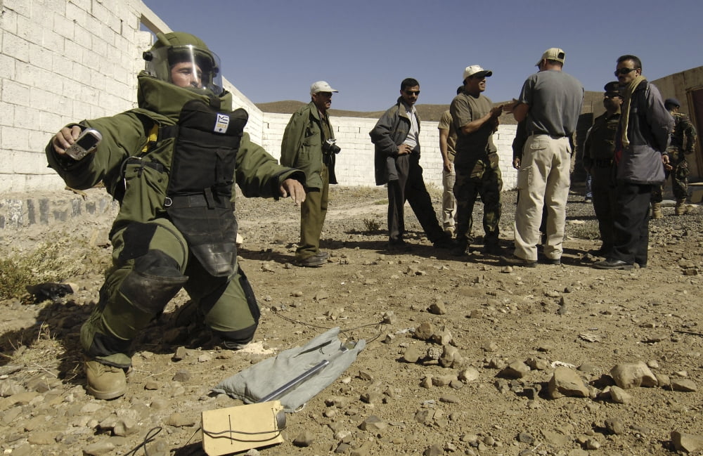 Yemen explosive ordnance disposal team members watch a Petty Officer dressed in a bomb suit destroy an explosive device Canvas Art - Stocktrek Images (35 x 23)