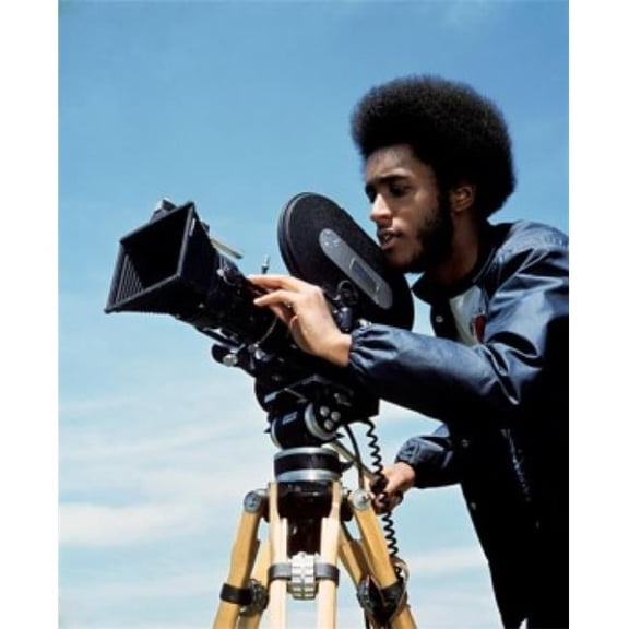 Young Man Operating a Movie Camera Poster Print - 18 x 24 in.