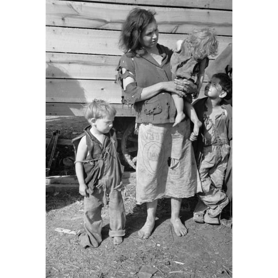 Young Mother Dressed In A Ragged Sweater And A Skirt Made Of A Flour Sack With Three Children Also Dressed In Rags. She Lives With Eight Others In A Field On Us Route 70 Between Camden And Bruceton