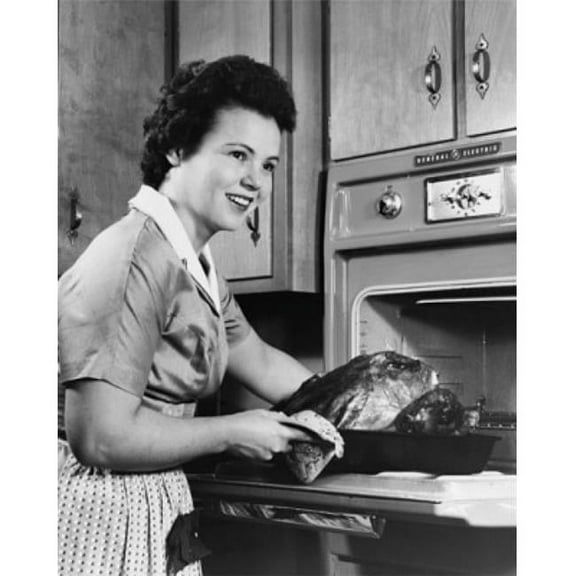 Young Woman Putting a Turkey Into an Oven Poster Print - 18 x 24 in.