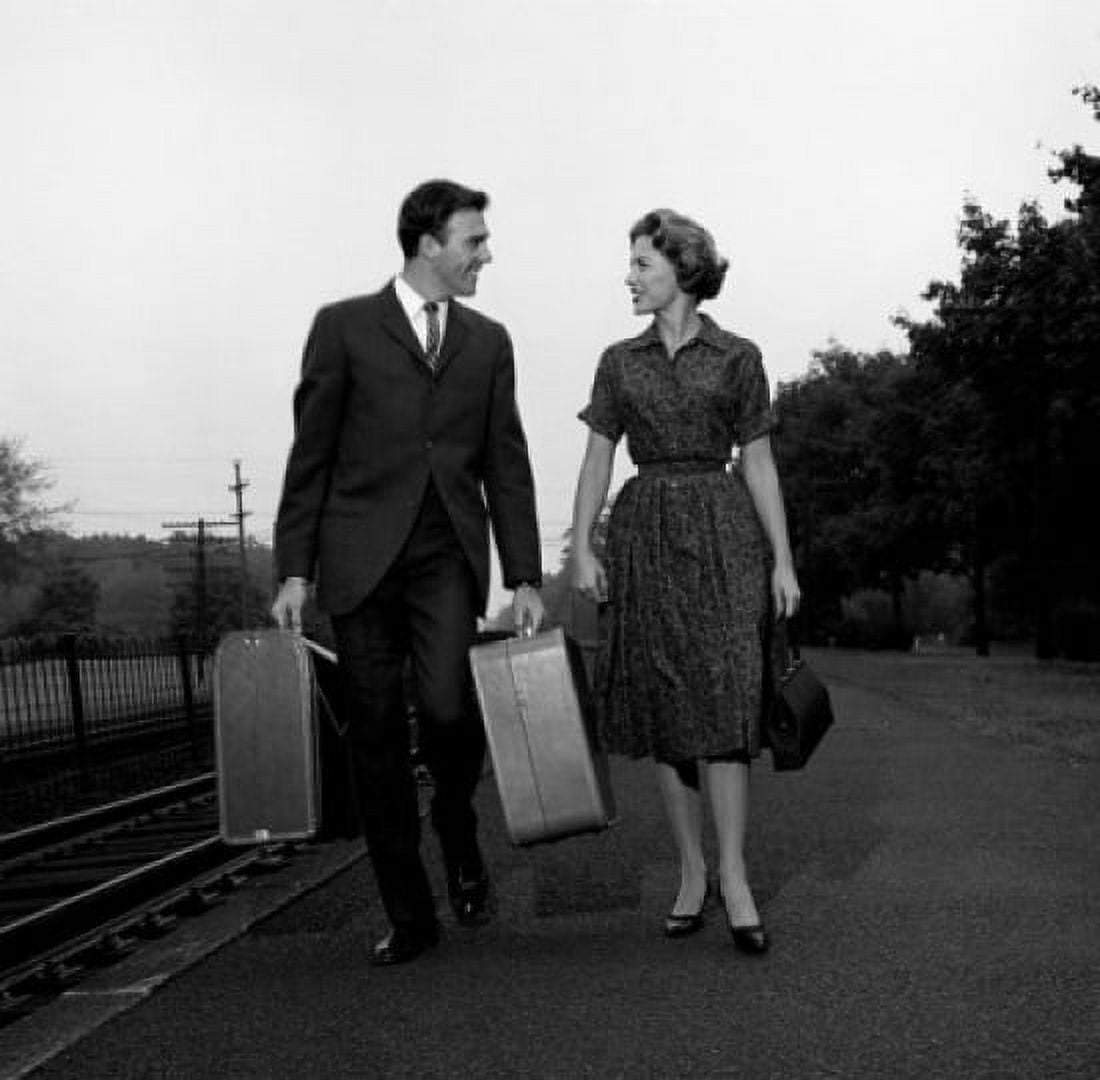 Young couple carrying suitcases at rail station Canvas Art - (24 x 36)