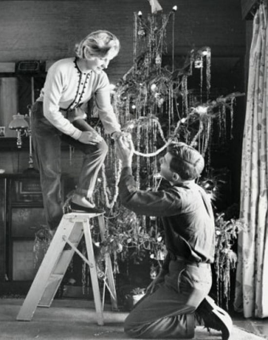 Young couple decorating a Christmas tree Canvas Art - (24 x 36)