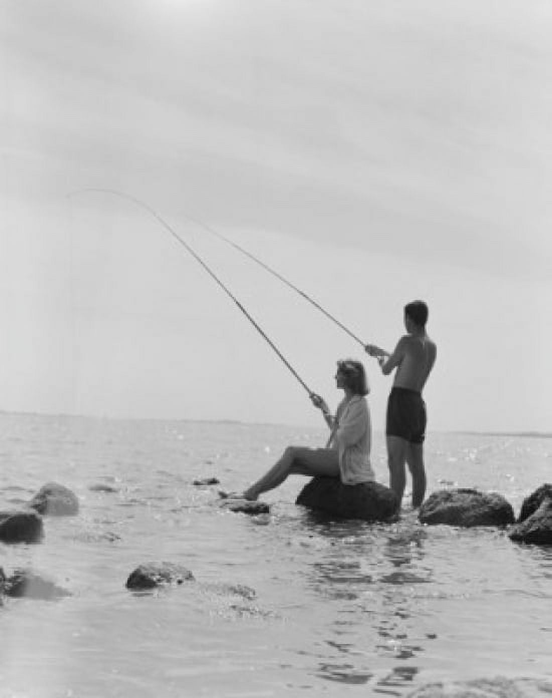 Young couple fishing on coastline Canvas Art - (24 x 36)