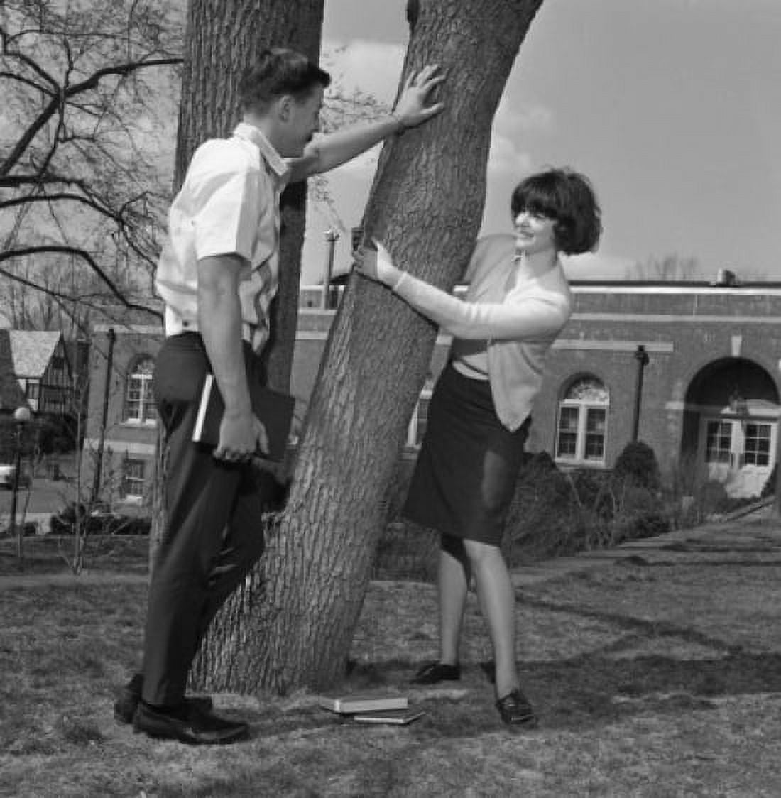 Young couple flirting by tree Canvas Art - (24 x 36)