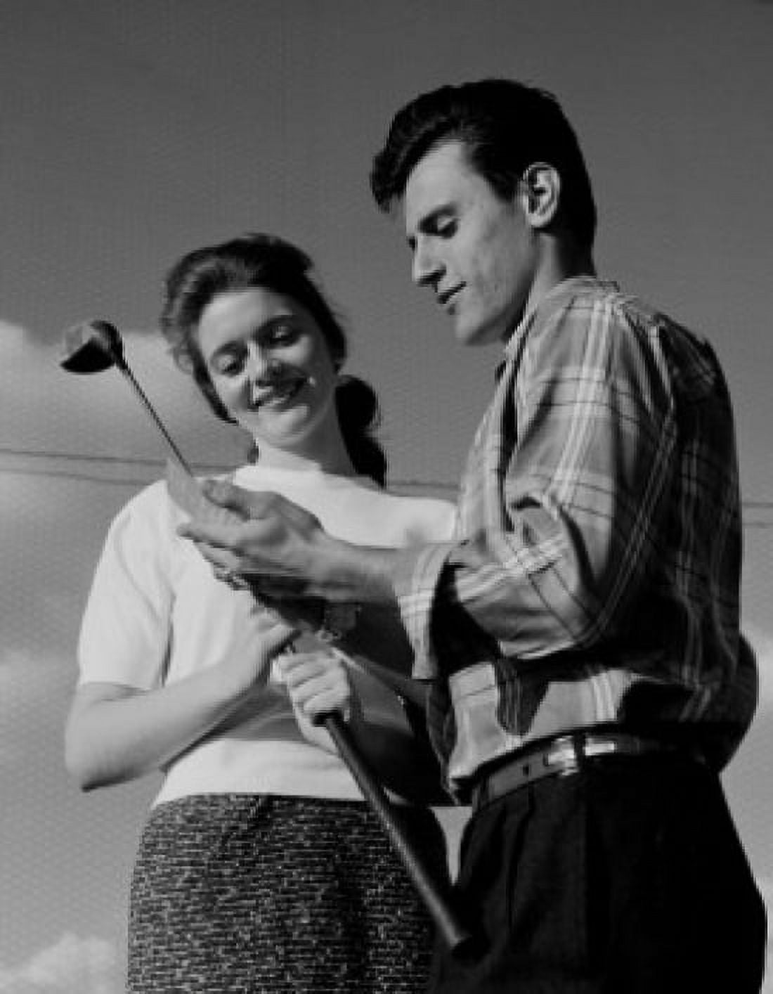 Young couple holding golf club and smiling low angle view Canvas Art - (24 x 36)