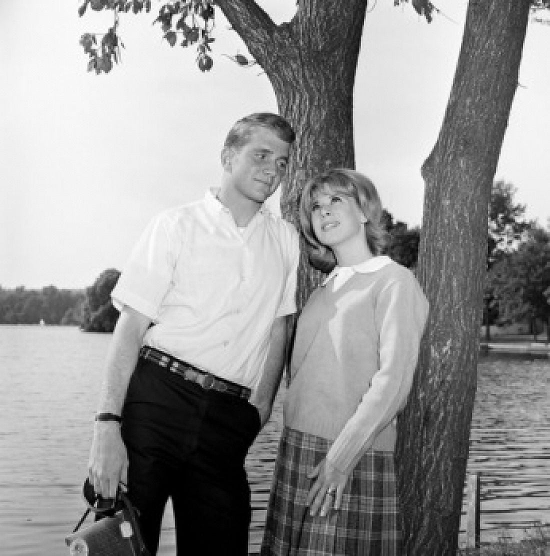Young couple leaning against tree trunk lake in background Canvas Art - (24 x 36)
