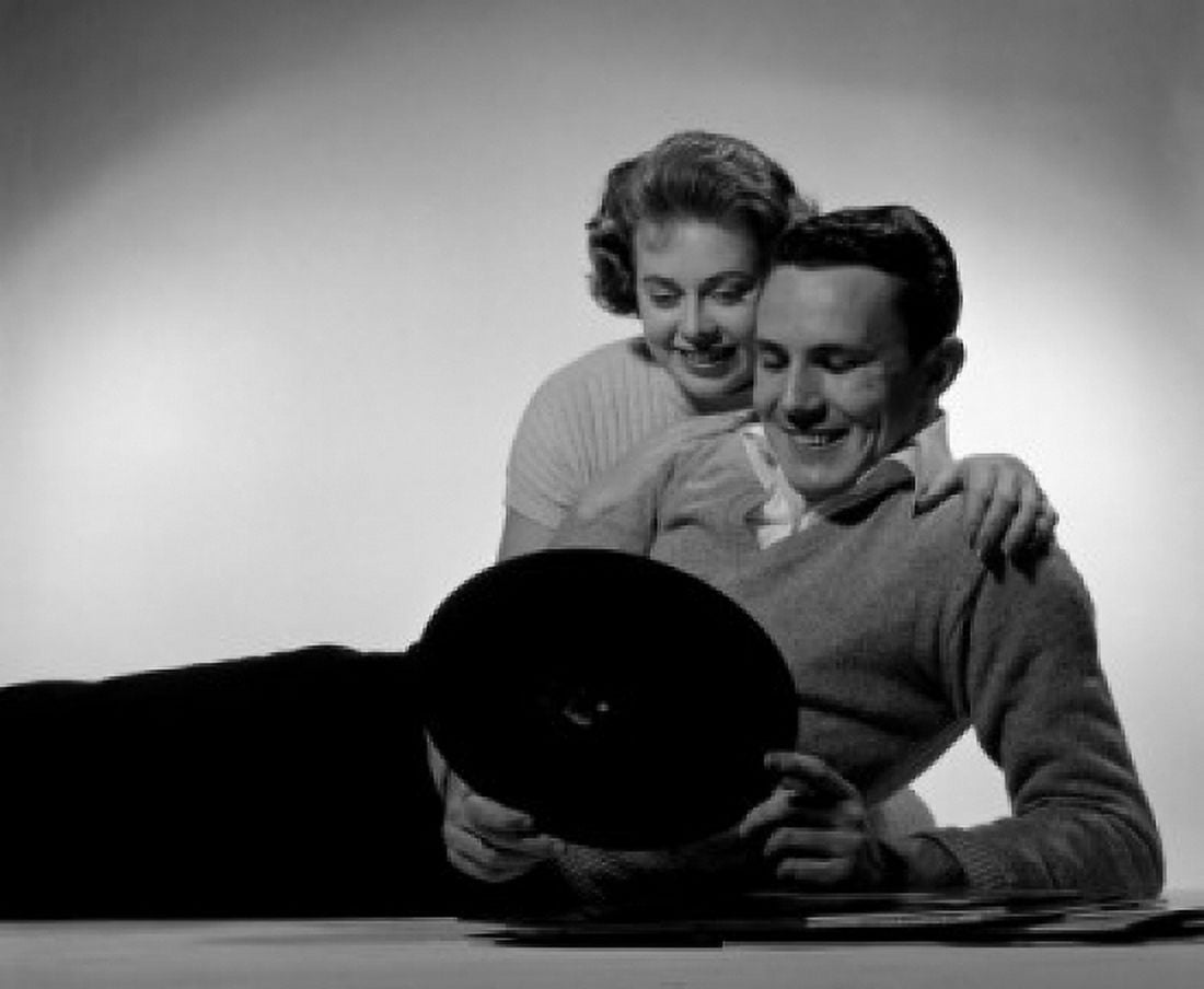 Young couple lying on floor looking at record Canvas Art - (24 x 36)