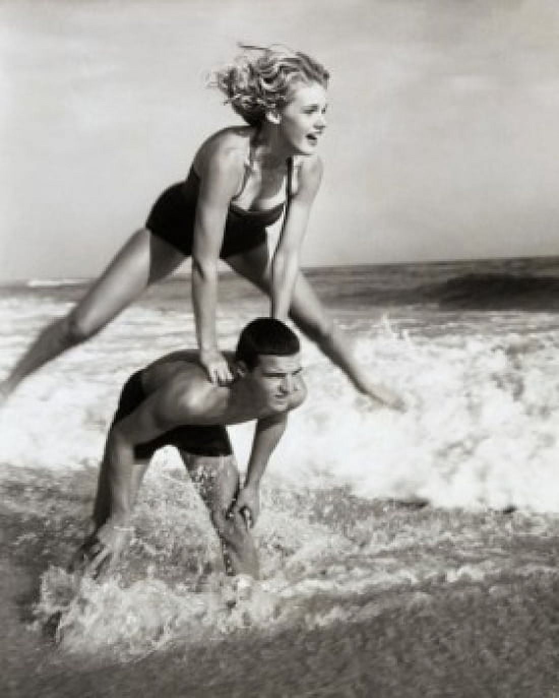 Young couple playing leapfrog in surf Canvas Art - (18 x 24)
