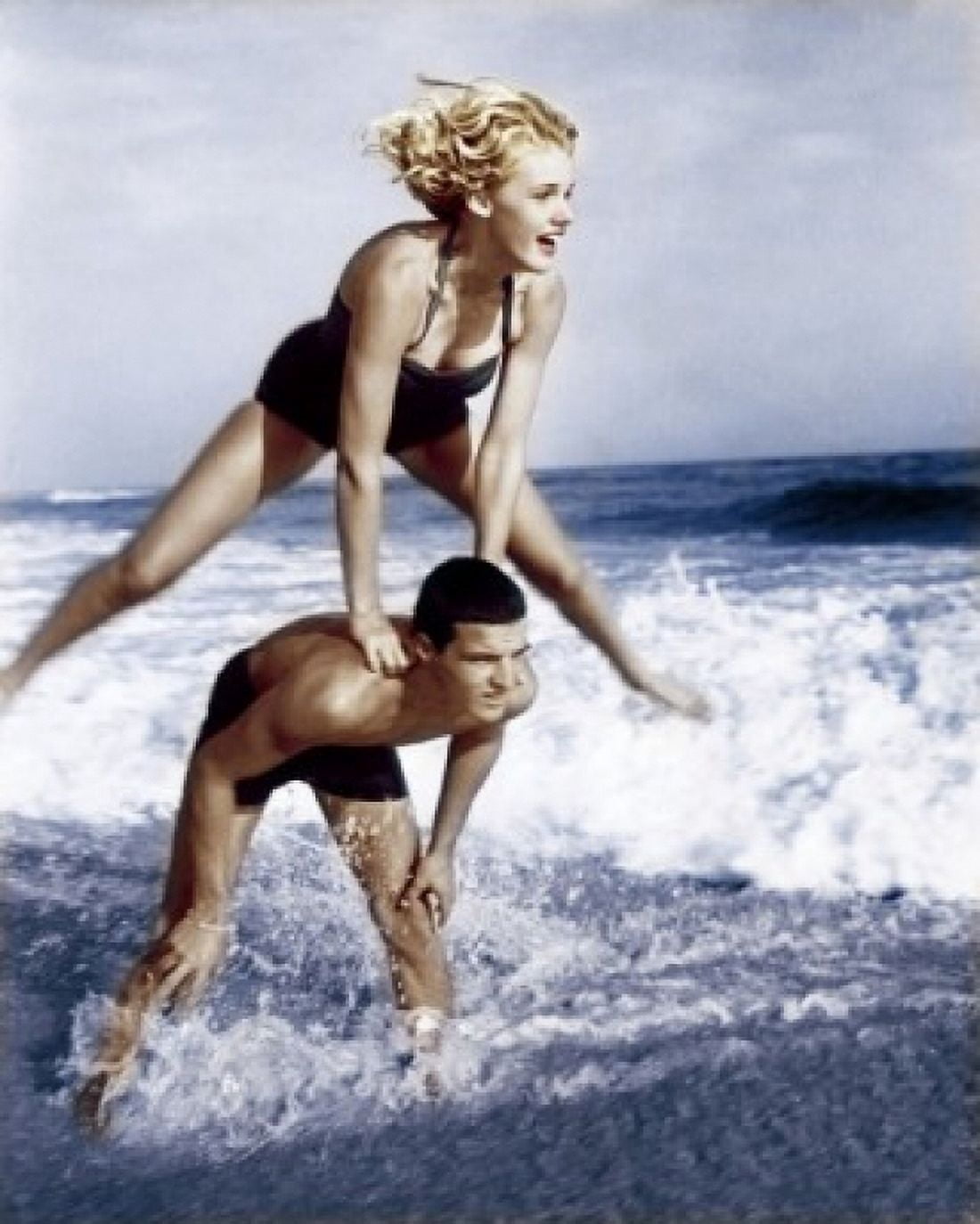 Young couple playing leapfrog in surf Canvas Art - (18 x 24)