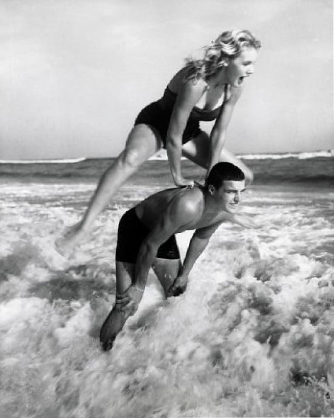 Young couple playing leapfrog in surf Canvas Art - (18 x 24)