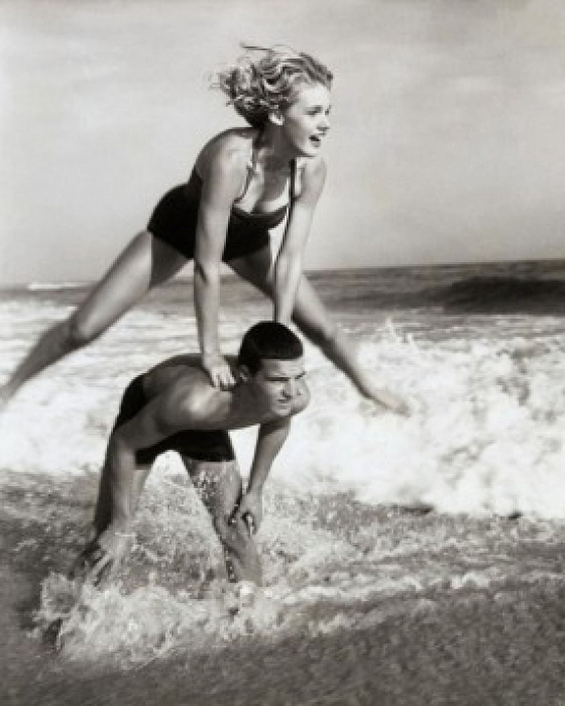 Young couple playing leapfrog in surf Canvas Art - (24 x 36)