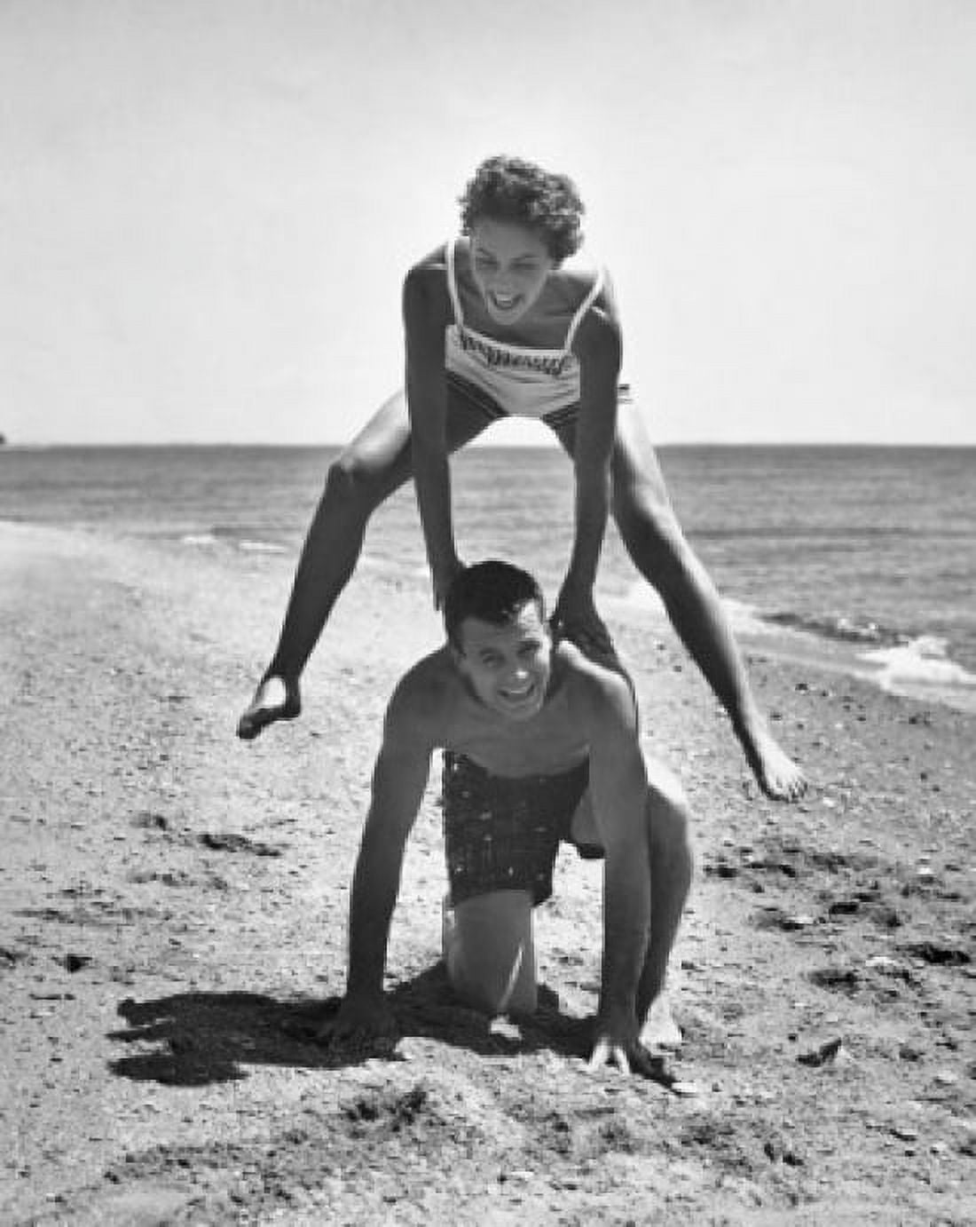 Young couple playing leapfrog on the beach Canvas Art - (18 x 24)