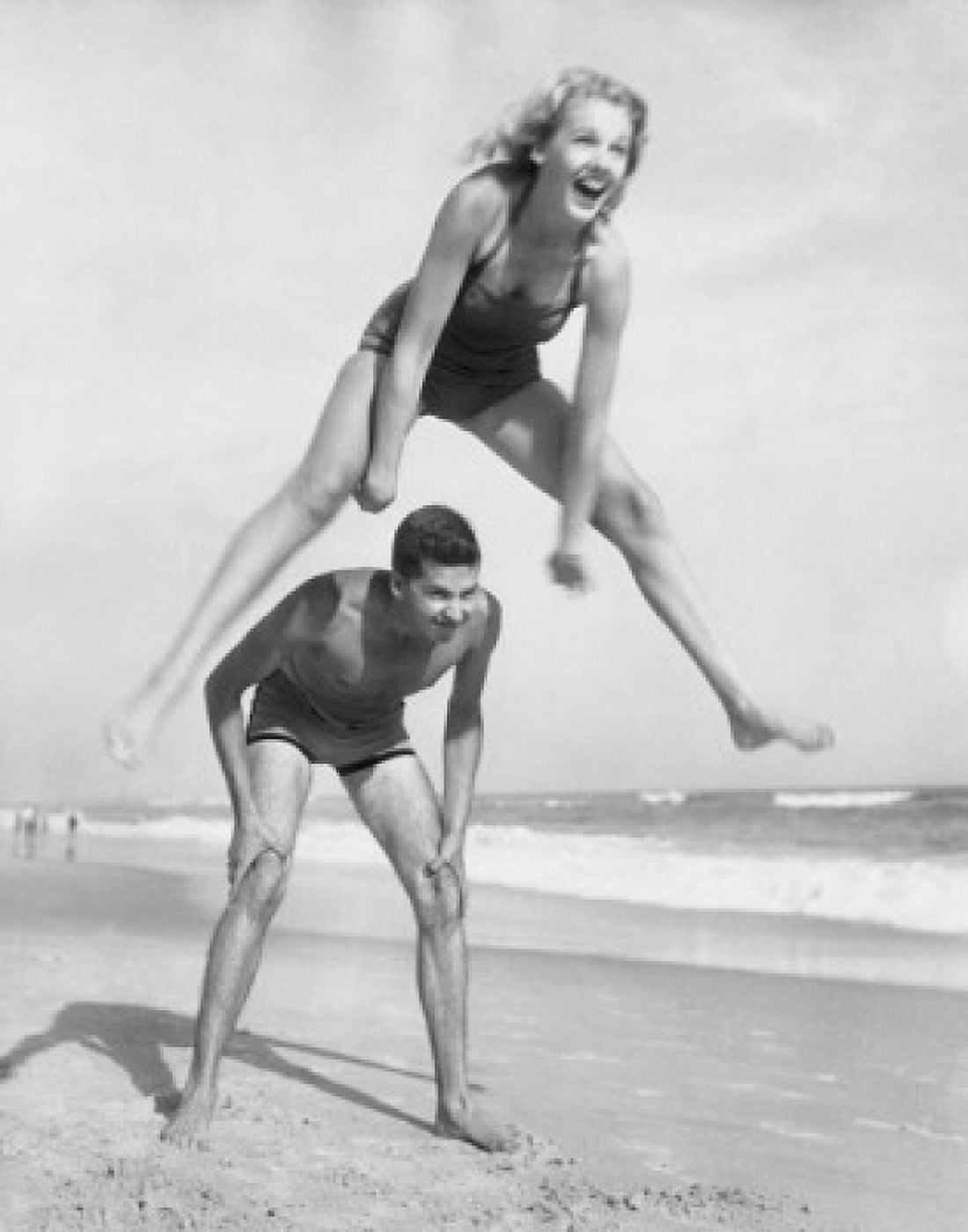 Young couple playing leapfrog on the beach Canvas Art - (18 x 24)