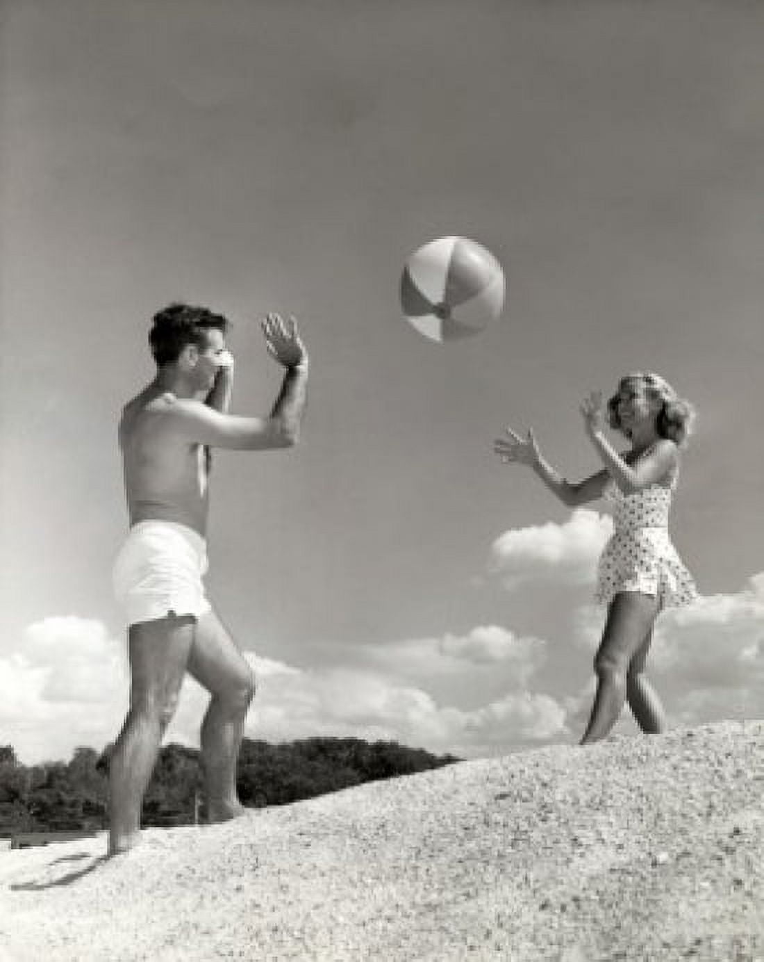 Young couple playing with a beach ball on the beach Canvas Art - (18 x 24)