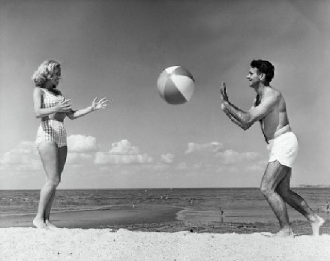 Young couple playing with beach ball on beach Canvas Art - (18 x 24)