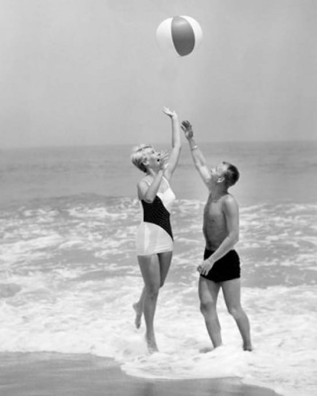Young couple playing with beach ball on beach Canvas Art - (24 x 36)