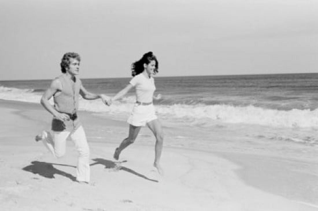 Young couple running across beach Canvas Art - (18 x 24)