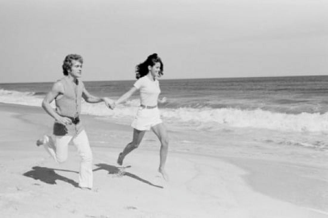 Young couple running across beach Canvas Art - (24 x 36)