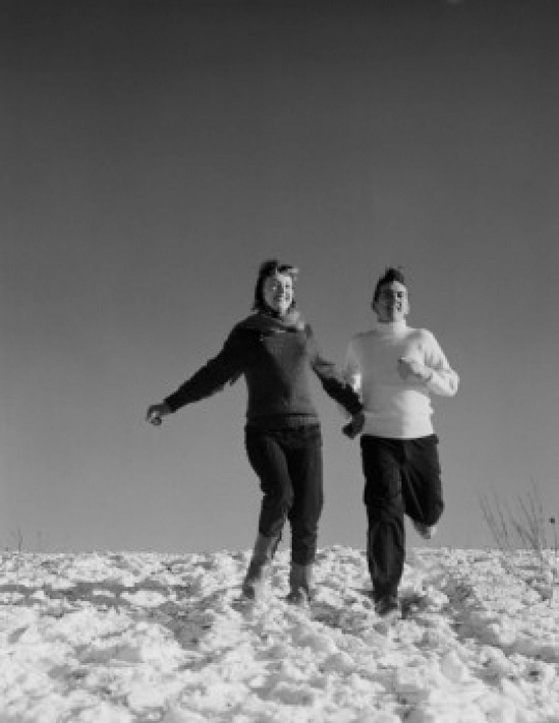 Young couple running down snowy hill Canvas Art - (24 x 36)